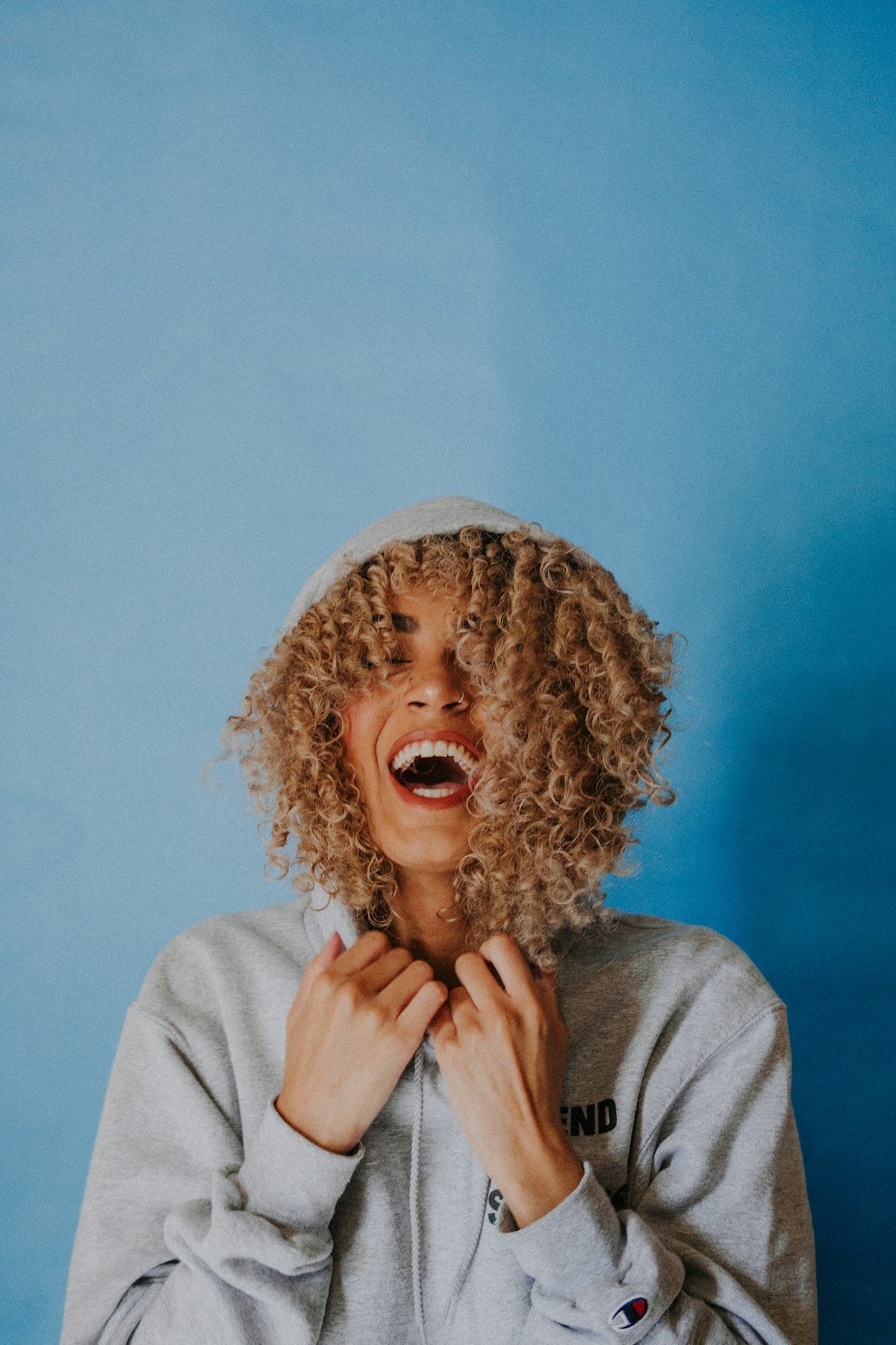 smiling woman wearing gray hoodie Image