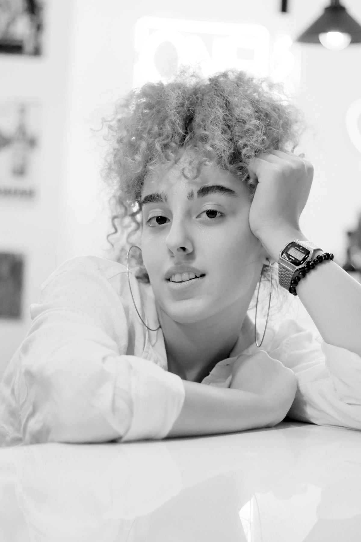 a woman with curly hair laying on a table Image