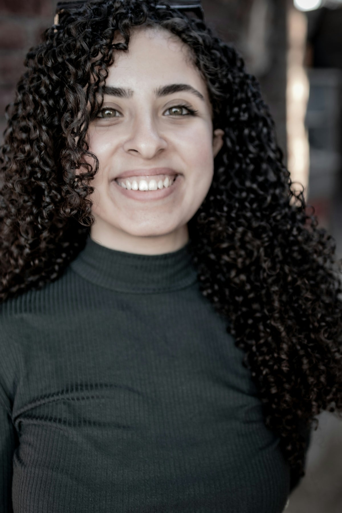 a woman with long curly hair smiling Image