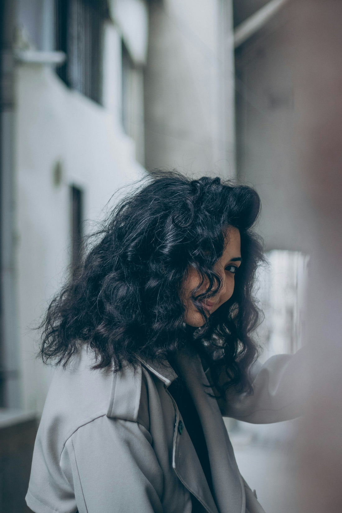 a woman with curly hair is looking at her cell phone