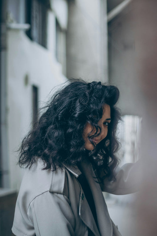 a woman with curly hair is looking at her cell phone